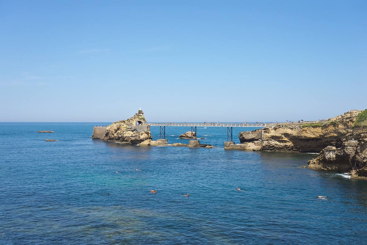 Le rocher de la Vierge à Biarritz relié à la côte par une passerelle métallique, au-dessus d'une mer bleue